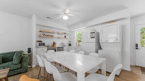 A modern kitchen with white appliances, a dining area with a white table and chairs, and a green sofa. - Pools/ Hot Tub / Whispering Woods Retreat (Branson)