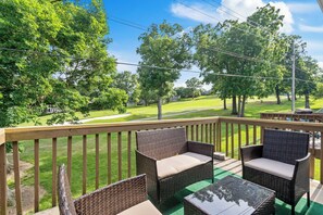 Relax on the balcony with wicker chairs and a small table, taking in the serene view of the lawn and golf course.