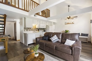 Relax in this open-plan living space with a high ceiling and comfortable seating area.