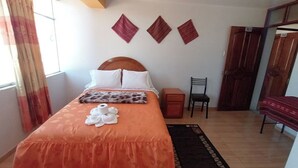 Une chambre à coucher avec un lit, une table de chevet, une chaise et une porte.