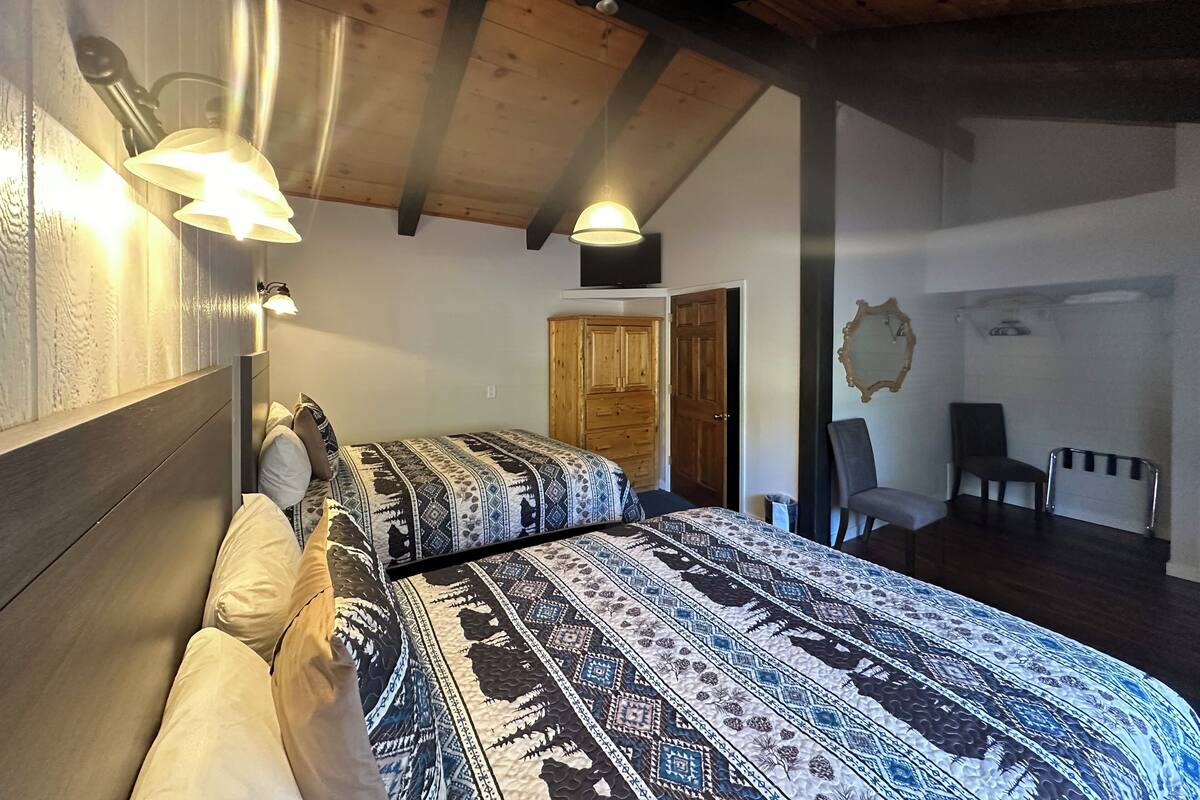 Un dormitorio con una cama grande, vigas de madera en el techo y un armario.