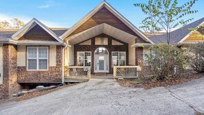 A two-story house with a stone facade, a gabled roof, and a front porch with railings. - The Greenview Manor - Lake View - 9 Miles from Silver Dollar City (Kimberling City)