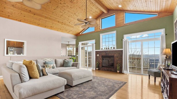 A spacious living room with a large sectional sofa, a fireplace, and a ceiling fan. - The Greenview Manor - Lake View - 9 Miles from Silver Dollar City (Kimberling City)