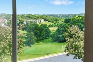 A view of a golf course with a clubhouse and surrounding greenery.
