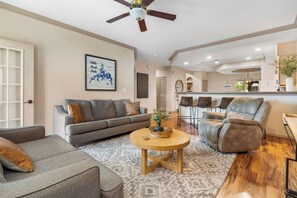A modern living room with a grey sofa, a round coffee table, and a recliner.