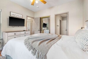 A bedroom with a large bed, a flat-screen TV mounted on the wall, a dresser, and a wardrobe. - Glorious Relaxation| Golf Course Views (Branson)
