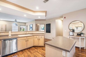 A modern kitchen with wooden cabinets, a stainless steel dishwasher, and a large island. - Glorious Relaxation| Golf Course Views (Branson)