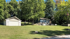 A two-story house with a garage and a covered outdoor seating area. - Charming 3-bedroom house across from Lake Freeman (Monticello)