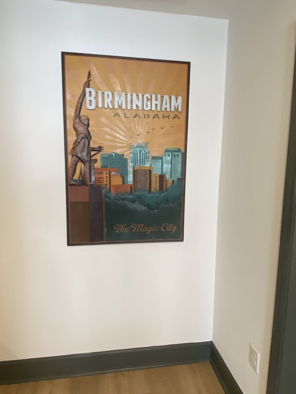 Un manifesto di Birmingham, Alabama, con una veduta urbana e una statua.