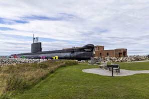Un sous-marin exposé, avec un bâtiment portant l’inscription « ONONDAGA POLICE-ARS » en arrière-plan.