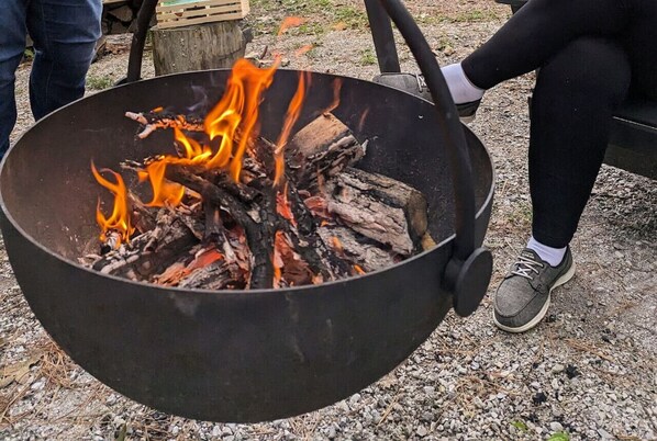 A large outdoor fire pit with logs and flames.