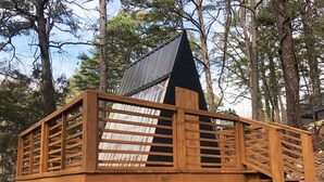 Una construcció de fusta amb teulada inclinada, envoltada d'arbres.