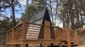 A wooden deck with a metal roof structure, surrounded by trees. - Loblolly Pines 3 Adventure Aframe (Eureka Springs)
