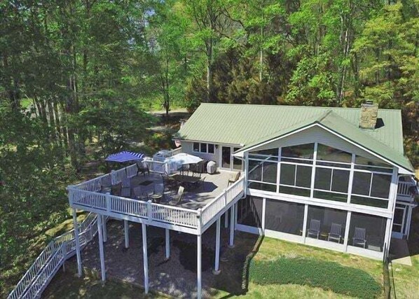 A two-story house with a covered deck and large windows.