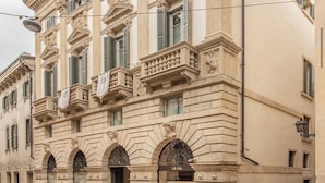 A historic building with classical architecture, featuring arched windows and decorative stonework.
