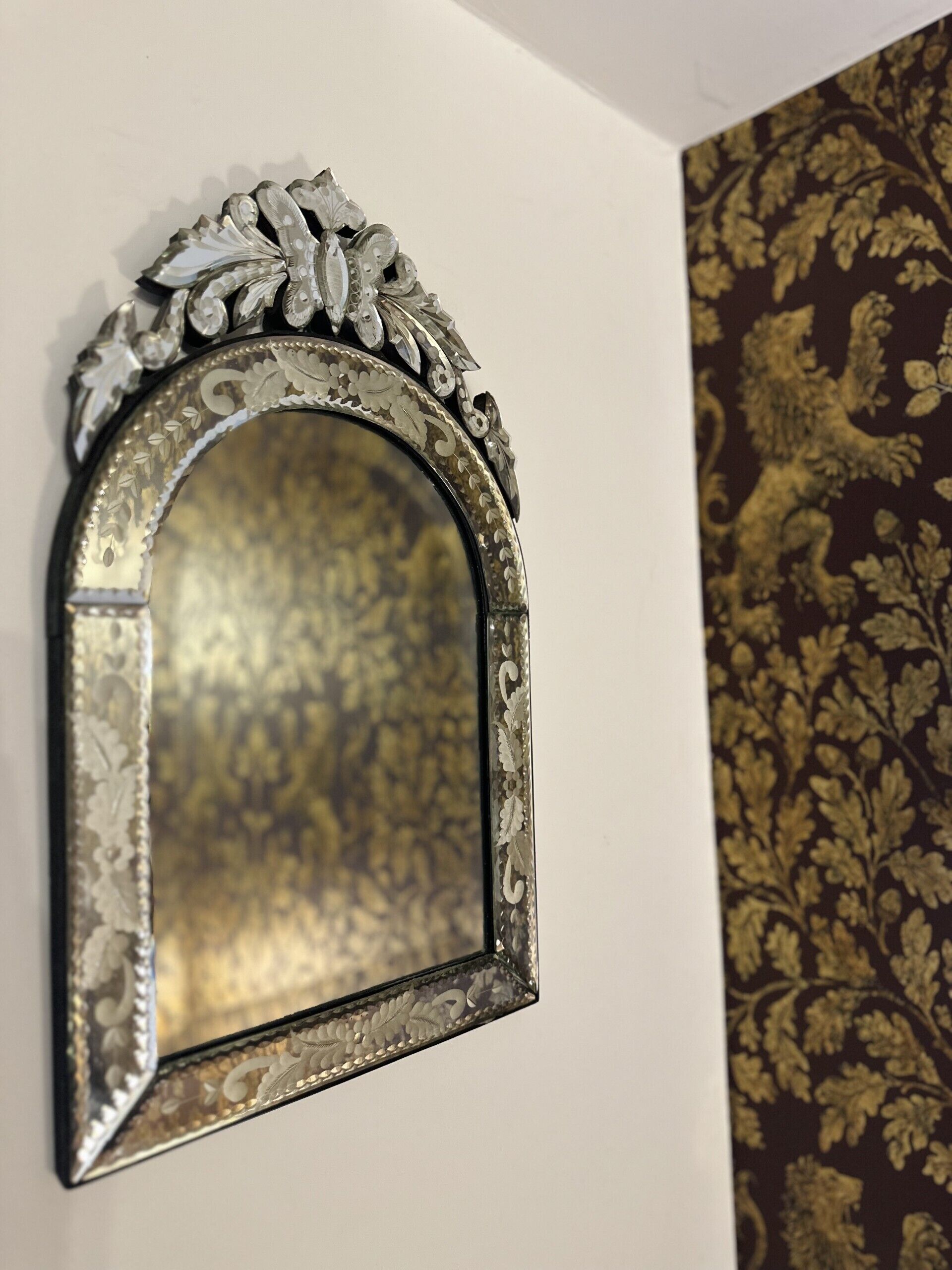 A wall-mounted mirror with an ornate metal frame.
