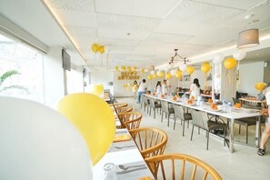 A dining area with tables, chairs, and yellow balloons. - Harris Resort Waterfront Batam (Sekupang)