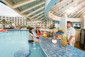 Ein Innenpool mit Bar, Liegestühlen und einem Poolrestaurant.