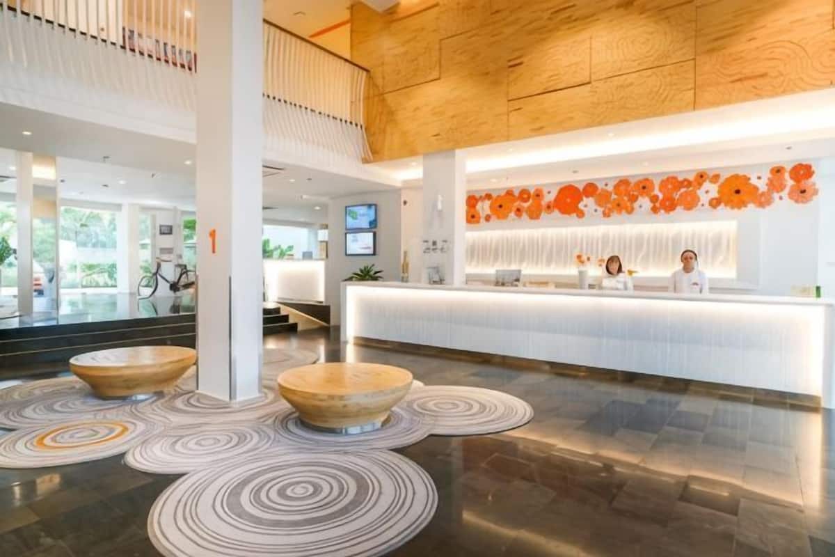 A modern reception area with a wooden ceiling, a reception desk, and a large window.
