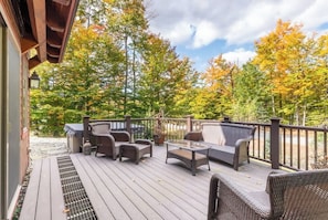 Relax on the deck surrounded by lush trees and enjoy the serene atmosphere.