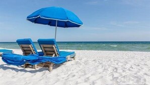 A beach with two blue sun loungers under a blue umbrella. - BEACHFRONT! OPEN CONCEPT! STUNNING 3 walls of  GLASS! (Pensacola)