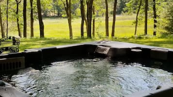 A hot tub with a view of a forested area.