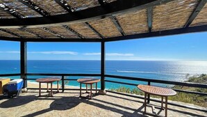 Un espacio de estar al aire libre cubierto con vistas al océano.