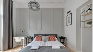 A modern bedroom with a bed, bedside tables, a desk, and a chair. - Forma by Grand Apartments (Sopot)
