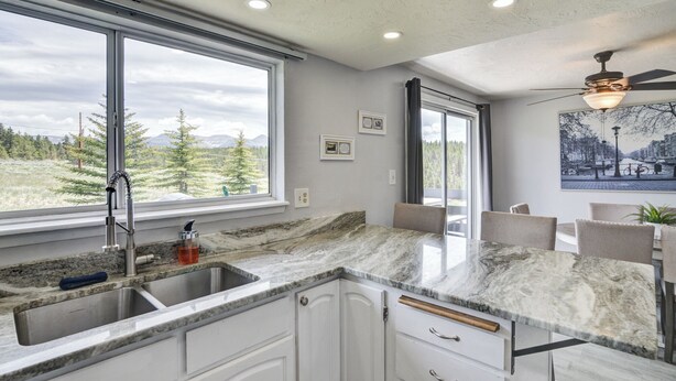 A kitchen with a large window, a sink, and a ceiling fan. - Sweet Dreams -MtnViews & Hot Tub (Leadville)