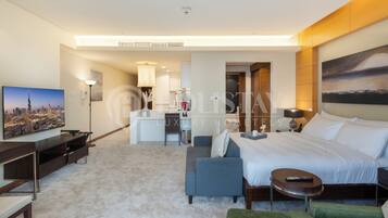 Une chambre d’hôtel moderne équipée d’un grand lit, d’un bureau, d’un canapé et d’une télévision.