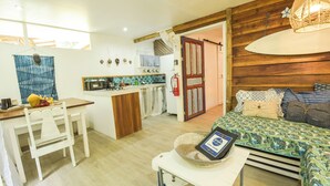 A compact living space with a kitchenette, a dining area, and a bedroom. - Mini Up House (Cahuita)