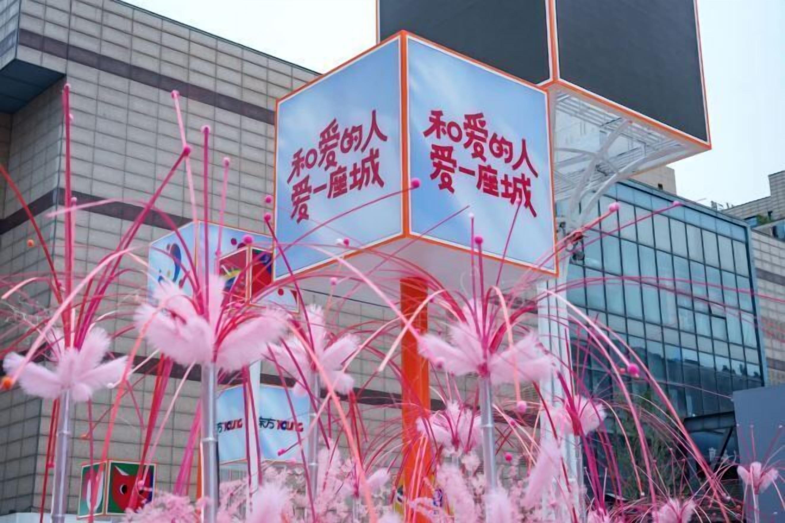 A modern building with a glass facade and a large sign with Chinese characters.