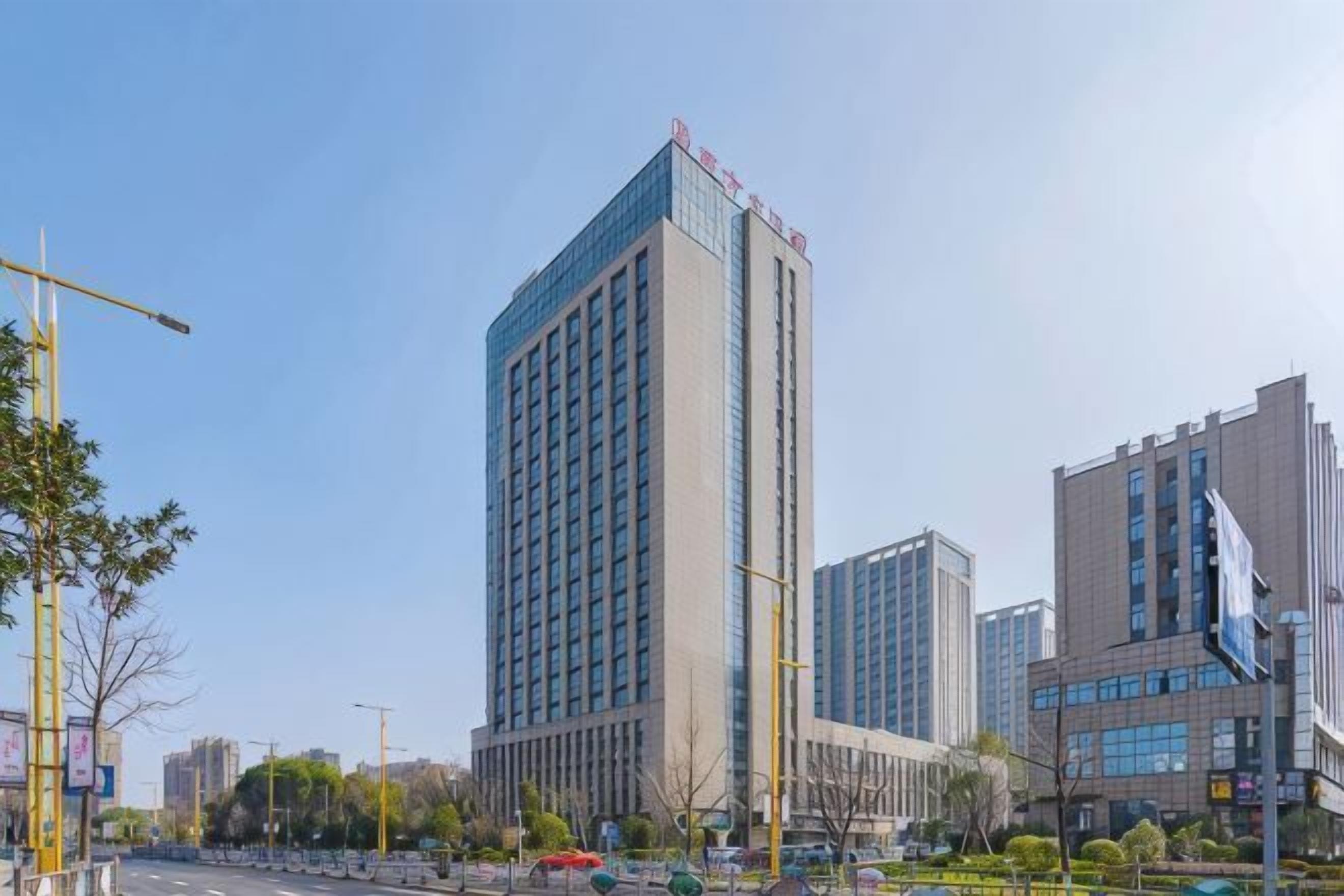 A tall building with a modern design, surrounded by other high-rise buildings.