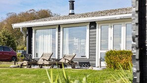 A modern house with a covered patio, large windows, and a car parked outside. - Stunning home in Aabenraa (Aabenraa)