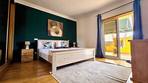 A bedroom with a bed, bedside tables, a painting, and a view of the outside. - Spacious Penthouse w/ Barbecue, wifi, 2 terraces & Views (Praia)