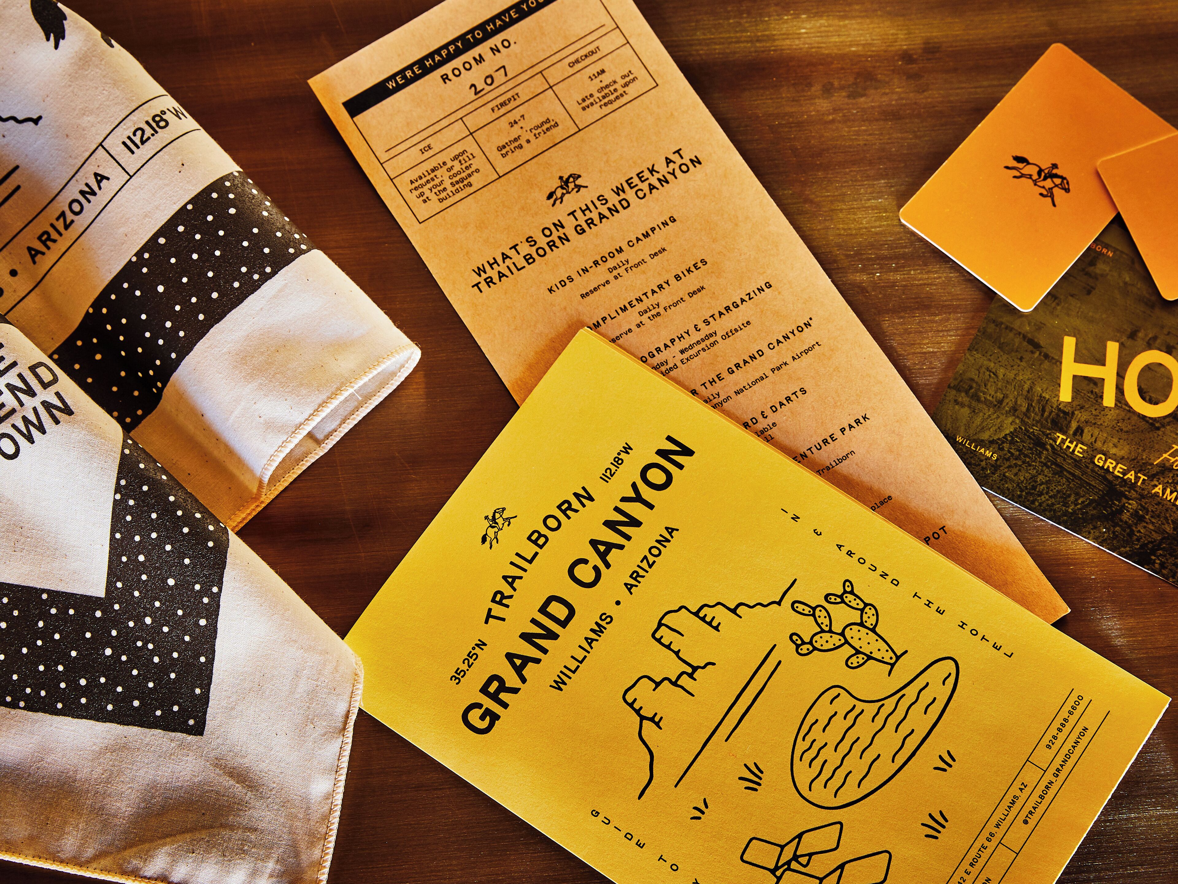 A variety of travel-related items including a map, a brochure, and a book titled "The Great American Home".