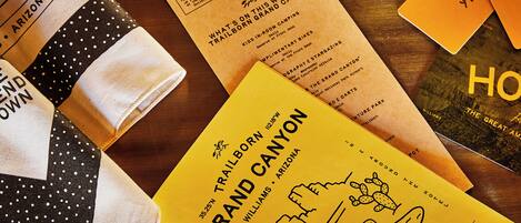 A variety of travel-related items including a map, a brochure, and a book titled "The Great American Home".