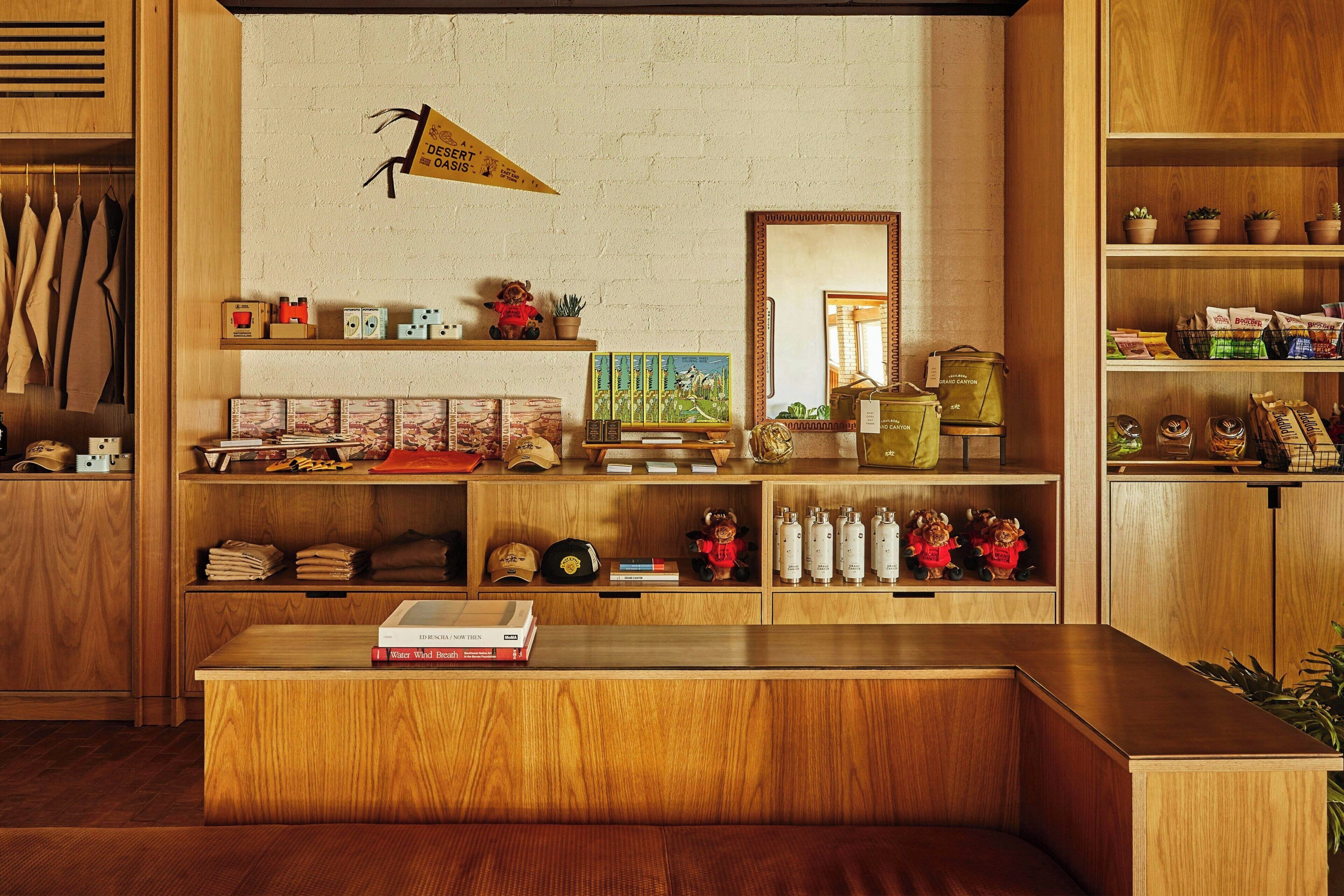 A wooden reception desk with a book, a mirror, and various items on shelves.