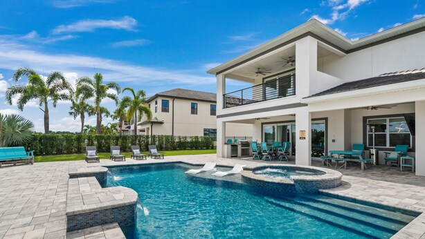 A modern two-story house with a swimming pool, outdoor seating, and palm trees. - Jacks Club Serenity Villa-TB026 (Kissimmee)