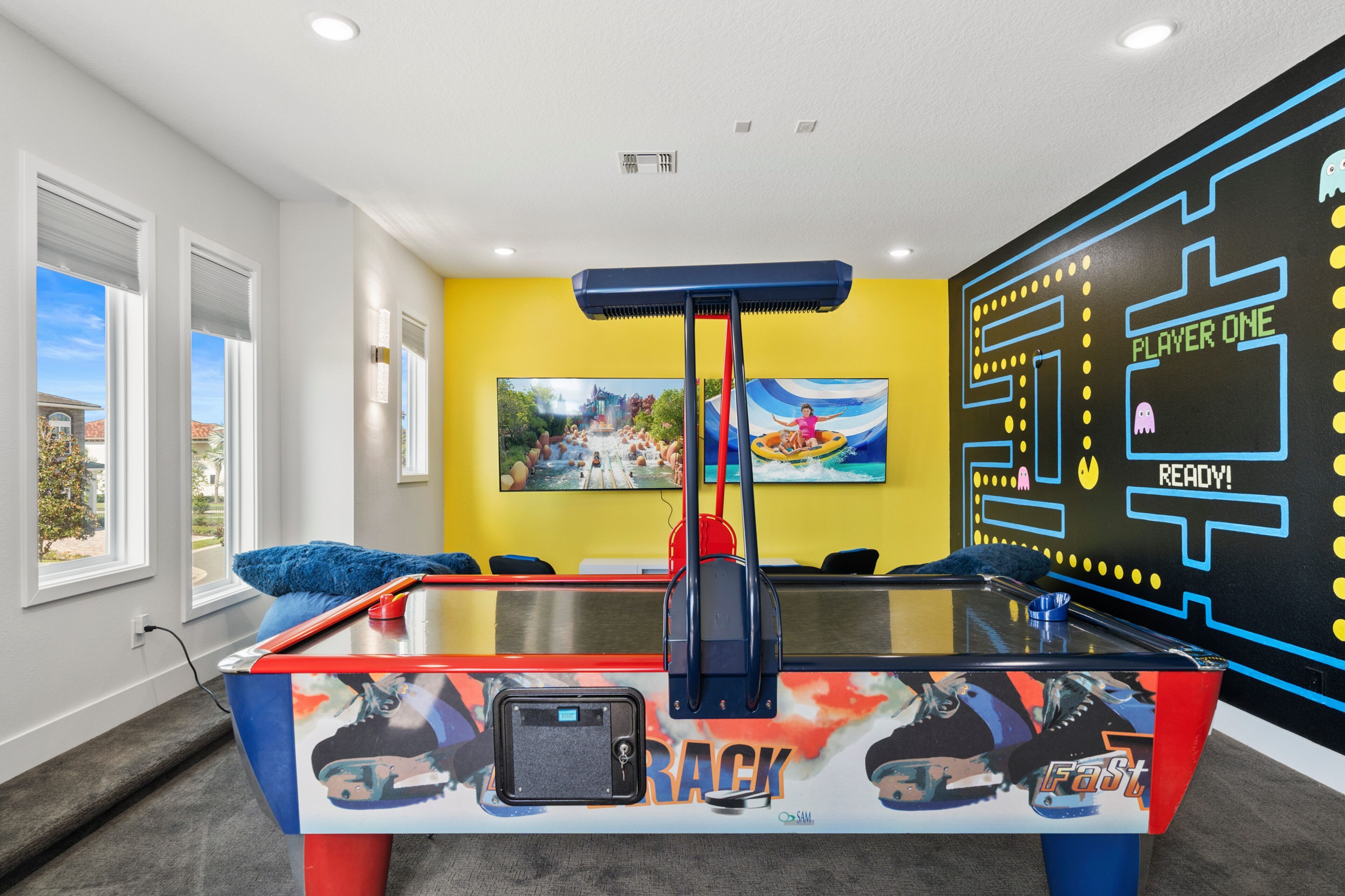 A pool table with a 'Fastest' theme, a large window, and a mural with a 'Player One' sign.