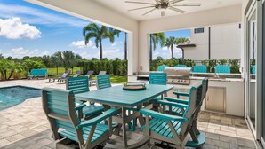 An outdoor patio with a pool, a dining table with chairs, a ceiling fan, and a barbecue grill. - Jacks Club Serenity Villa-TB026 (Kissimmee)