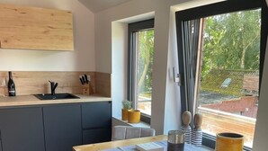 Una cocina moderna con encimera de madera, un fregadero y una ventana con vistas a zonas verdes.