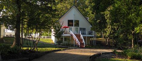 A two-story house with a covered porch and a staircase leading to the upper level.