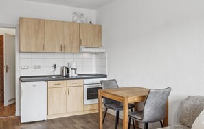 Compact kitchen with oven, dishwasher, and ample counter space for dining or working.