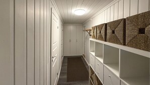 A narrow hallway with white paneling, a wooden floor, and a built-in shelving unit with woven baskets. - 2 bedroom nice apartment in Vegårshei (Vegårshei)