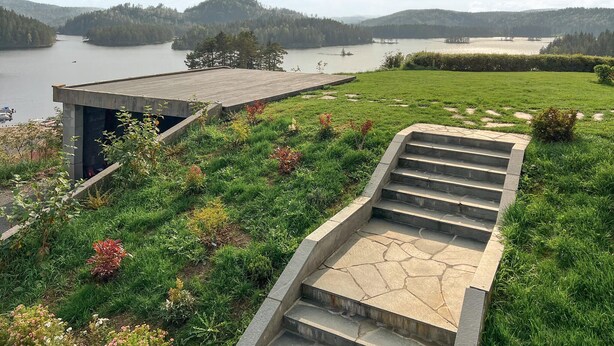 A modern outdoor staircase leading to a deck overlooking a lake, surrounded by lush greenery and a clear view of distant hills. - 2 bedroom nice apartment in Vegårshei (Vegårshei)