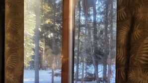 A window with a view of a snowy forest and a wooden deck. - Pinescape: Cabin•WiFi•Wood Fireplace•Pet friendly•Fish•Relaxation (Big River)