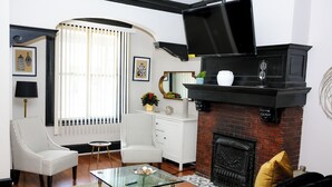 A living room with a fireplace, two chairs, a sofa, and a coffee table.