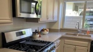 Une cuisine équipée d’une cuisinière, d’un four, d’un four à micro-ondes et de placards.