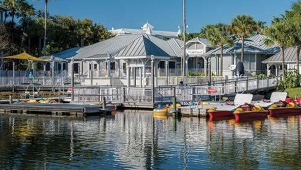 A waterfront property with a covered dock, boats, and a building with a grey roof. - Fantastic condo in Orlando; fully equipped kitchen, washer/dryer, WiFi (Orlando)